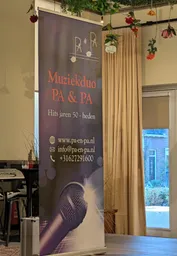 De banner van Muziekduo PA & PA met contactinformatie staat ook op het podium.